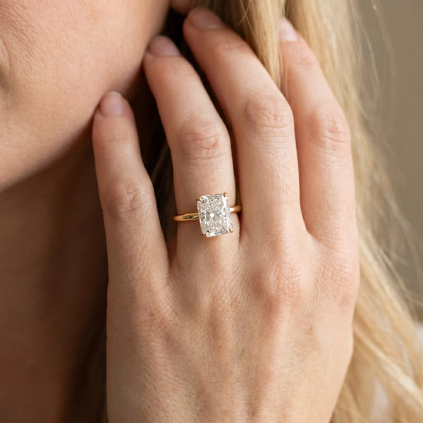 Yellow gold Radiant Cut Solitaire Engagement Ring with Four-Prong Setting and Classic Band