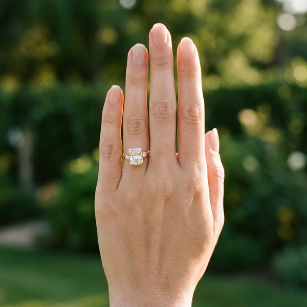 Yellow gold Radiant Cut Three-Stone Solitaire Ring with Round Accent Diamonds and Four-Prong Setting