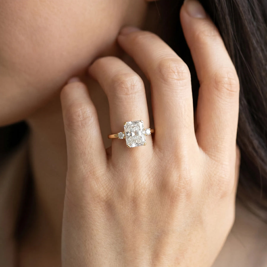 Yellow gold Radiant Cut Three-Stone Solitaire Ring with Round Accent Diamonds and Four-Prong Setting