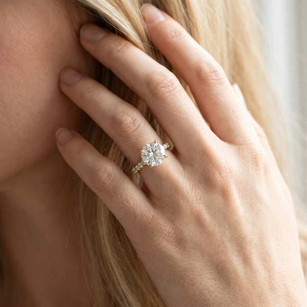 Yellow gold Round Brilliant Diamond Solitaire with Pavé Band and Four-Prong Setting