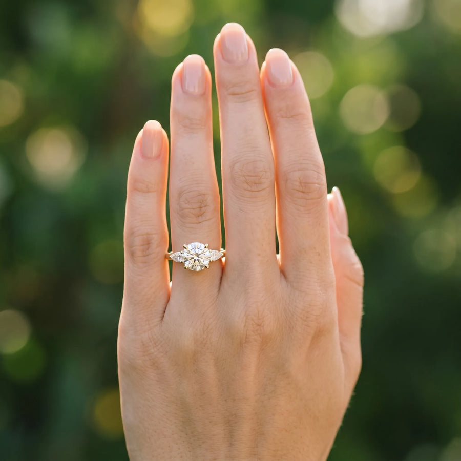 Yellow gold Round Brilliant Three-Stone Ring with Pear Side Stones and Four-Prong Setting