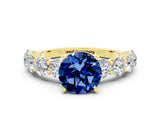 Yellow gold Round Cut Blue Sapphire Prong Setting with Side Stones on a Pave Band