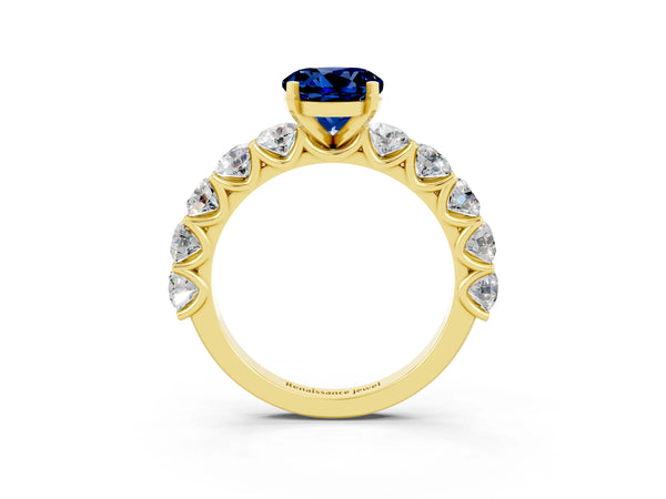 Yellow gold Round Cut Blue Sapphire Prong Setting with Side Stones on a Pave Band