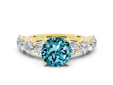 Yellow gold Round Cut Blue Topaz Prong Setting with Side Stones on a Pave Band