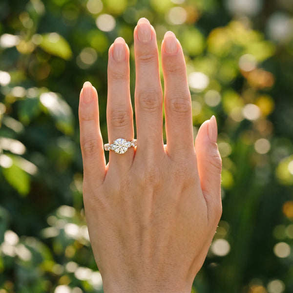 Yellow gold Round Cut Diamond Prong Setting with Side Stones on a Pave Band