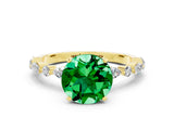 Yellow gold Round Cut Emerald Solitaire with Side Stones on a Pavé Band and Four-Prong Setting