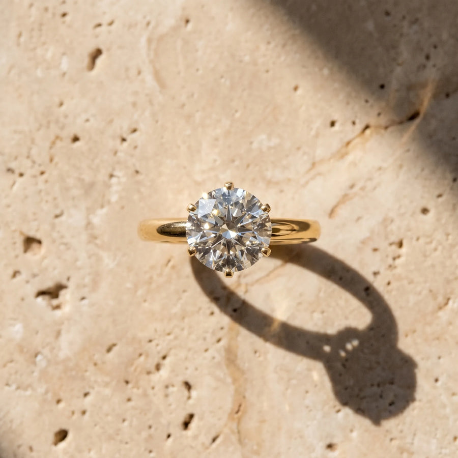Yellow gold Round Solitaire Diamond Ring with Six-Prong Setting on a Classic Band