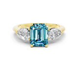 Yellow gold Three-Stone Emerald Cut Blue Topaz Ring with Pear Side Stones and Four-Prong Setting