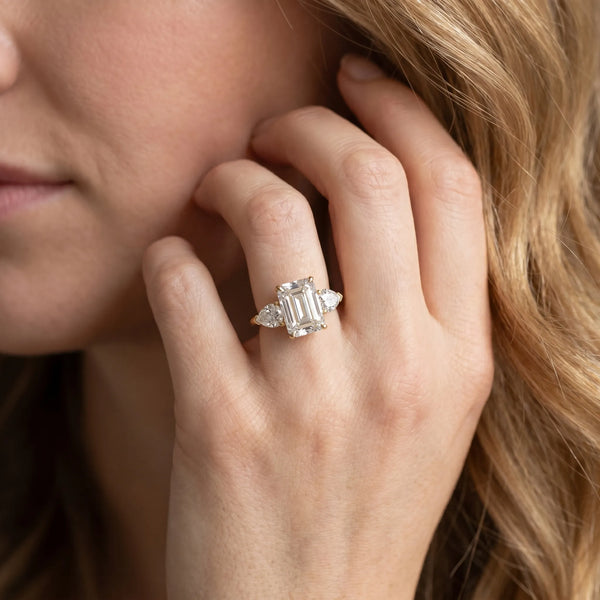 Yellow gold Three-Stone Emerald Cut Diamond Ring with Pear Side Stones and Four-Prong Setting