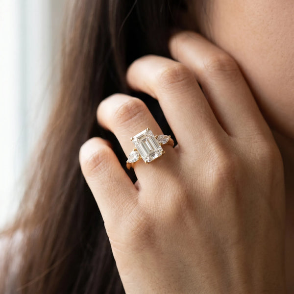 Yellow gold Three-Stone Emerald Cut Diamond Ring with Pear Side Stones in Four-Prong Setting