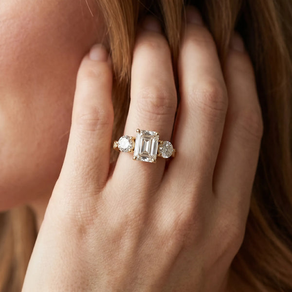 Yellow gold Three-Stone Emerald Diamond Engagement Ring with Prong Setting on a Classic Band