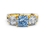 Yellow gold Three-Stone Fancy Blue Cushion Cut Diamond Ring with Round Side Stones, Classic Band, and Four-Prong Setting
