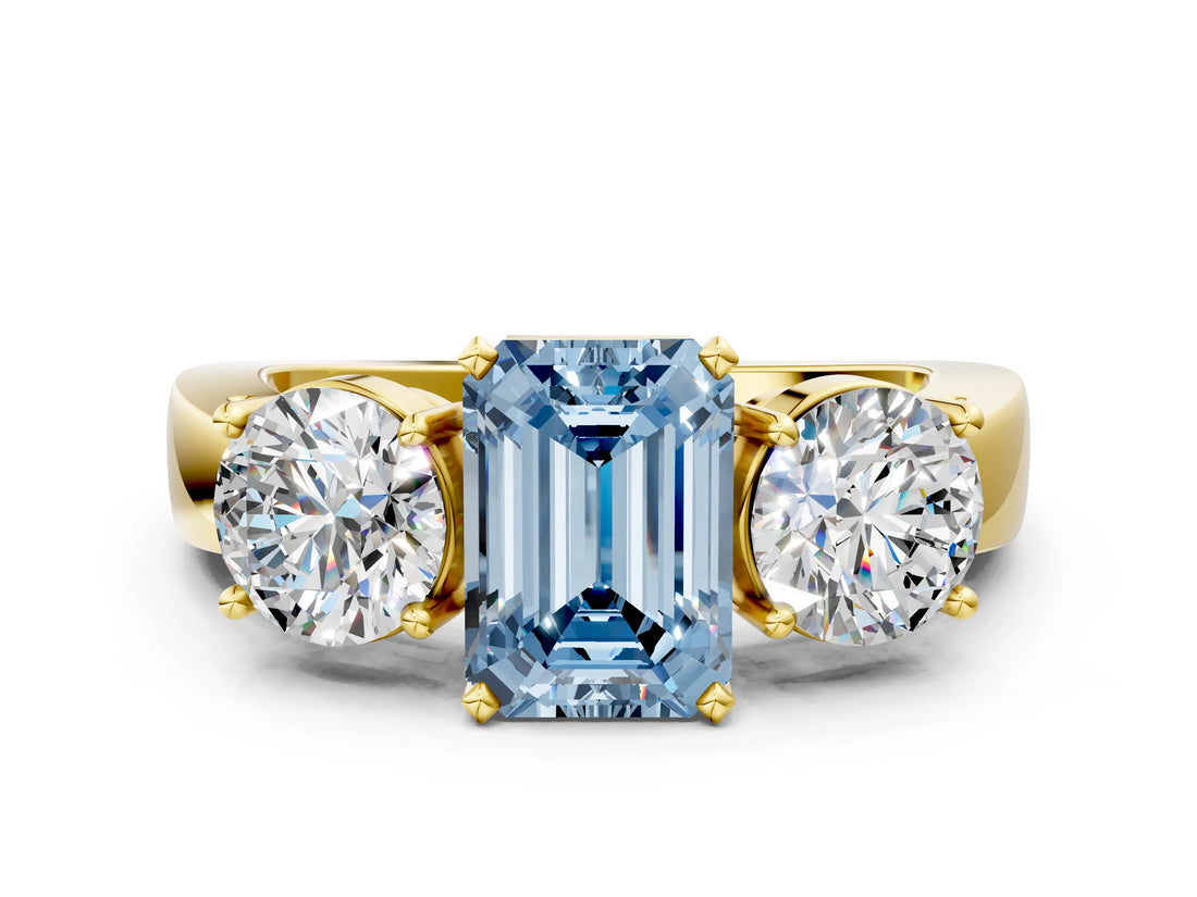 Yellow gold Three-Stone Fancy Blue Emerald Cut Diamond Ring with Round Side Stones, Classic Band, and Four-Prong Setting