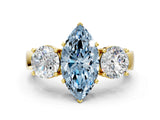 Yellow gold Three-Stone Fancy Blue Marquise Cut Diamond Ring with Round Side Stones, Classic Band, and Four-Prong Setting