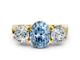 Yellow gold Three-Stone Fancy Blue Oval Cut Diamond Ring with Round Side Stones, Classic Band, and Four-Prong Setting
