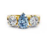 Yellow gold Three-Stone Fancy Blue Pear Cut Diamond Ring with Round Side Stones, Classic Band, and Four-Prong Setting