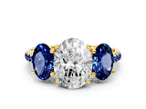 Yellow gold Three-Stone Oval Cut Diamond Ring with Round with Blue Sapphire side stone Pavé Band and Prong Setting