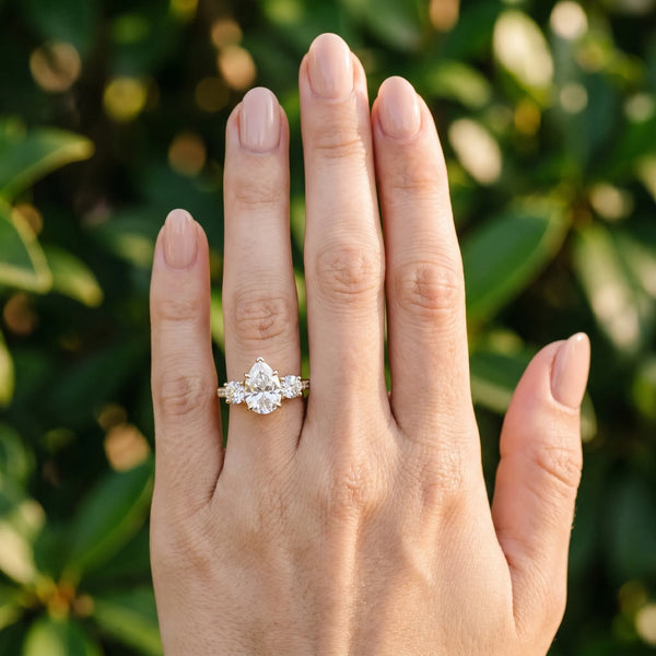 Yellow gold Three-Stone Pear Cut Diamond Ring with Round Accent Stones, Prong Setting, and Classic Band
