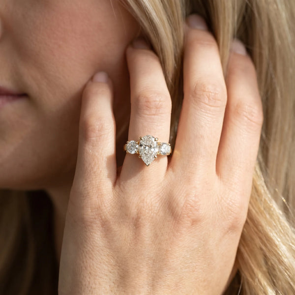 Yellow gold Three-Stone Pear Cut Diamond Ring with Round Accent Stones, Prong Setting, and Classic Band