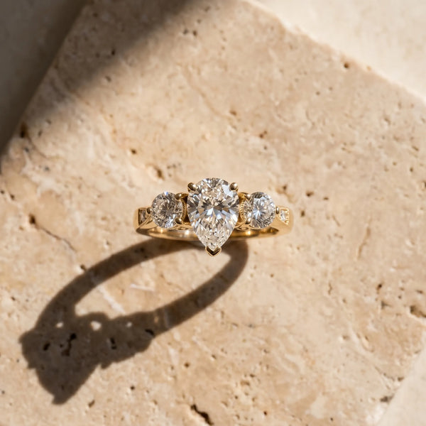 Yellow gold Three-Stone Pear Diamond Engagement Ring with Prong Setting on a Classic Band