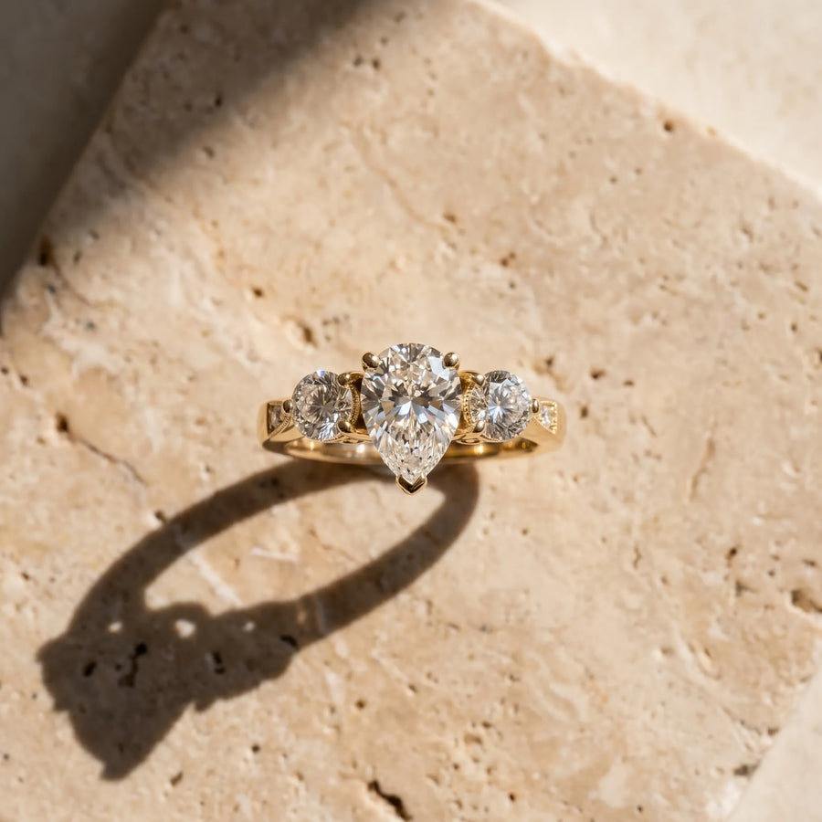 Yellow gold Three-Stone Pear Diamond Engagement Ring with Prong Setting on a Classic Band