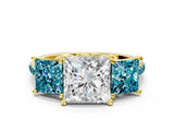 Yellow gold Three-Stone Princess Cut Diamond Ring with Round with Blue Topaz side stone Pavé Band and Prong Setting
