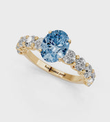 Yellow gold Fancy Blue Oval Cut Diamond Prong Setting with Side Stones on a Pave Band