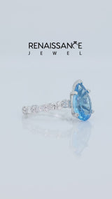Silver Pear Cut Blue Topaz Side Stone Solitaire Ring with Round and Four-Prong Setting