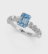 White gold Fancy Blue Emerald Cut Diamond Prong Setting with Side Stones on a Pave Band