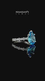 Silver Pear Cut Blue Topaz Side Stone Solitaire Ring with Round and Four-Prong Setting