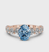 Rose gold Fancy Blue Oval Cut Diamond Prong Setting with Side Stones on a Pave Band