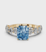 Yellow gold Fancy Blue Radiant Cut Diamond Prong Setting with Side Stones on a Pave Band