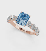 Rose gold Fancy Blue Radiant Cut Diamond Prong Setting with Side Stones on a Pave Band