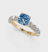 Yellow gold Fancy Blue Cushion Cut Diamond Prong Setting with Side Stones on a Pave Band