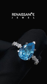 Silver Pear Cut Blue Topaz Side Stone Solitaire Ring with Round and Four-Prong Setting